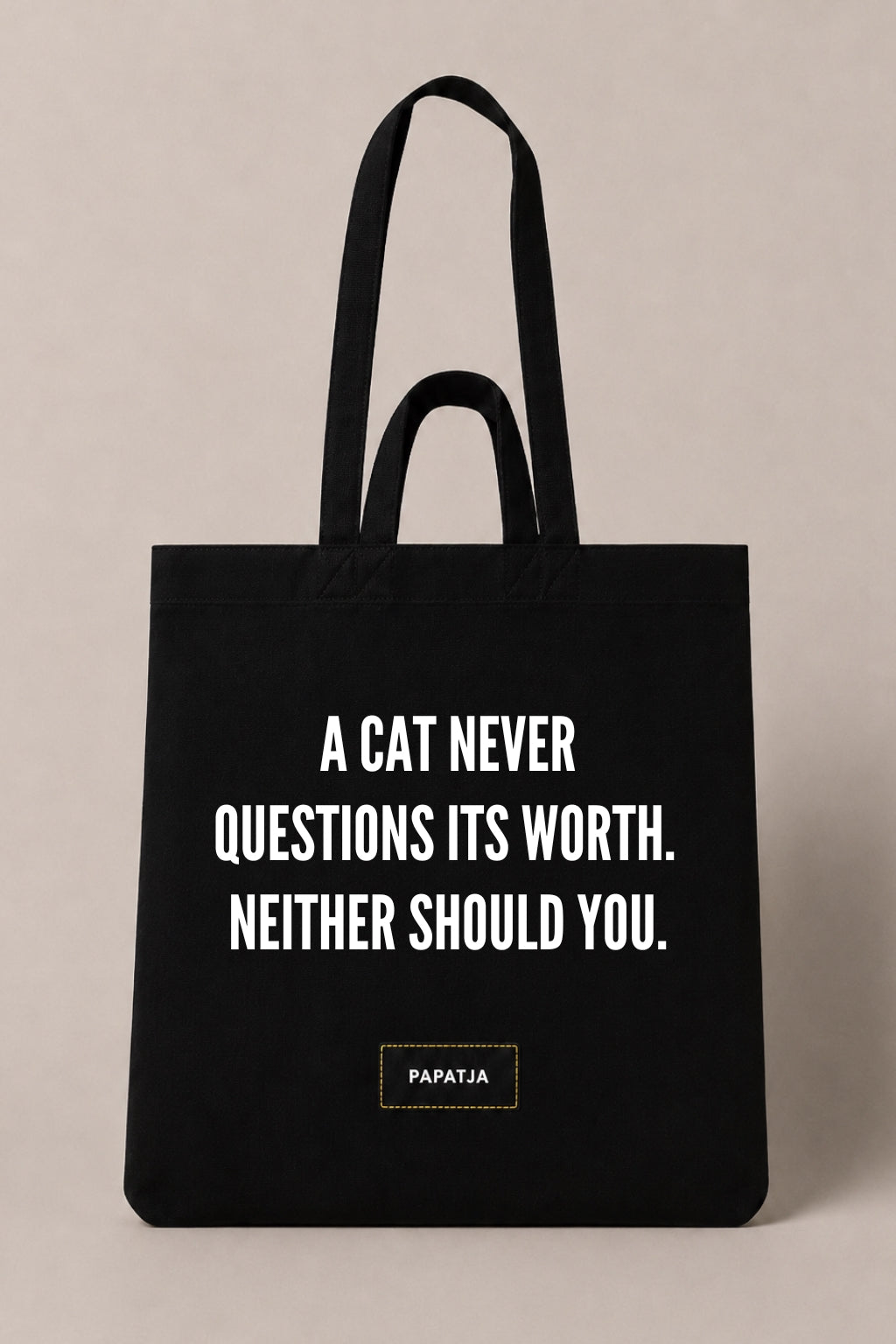 Black cotton PAPATJA tote bag with the quote A Cat Never Questions Its Worth. Neither Should You, a thoughtful gift for cat lovers.