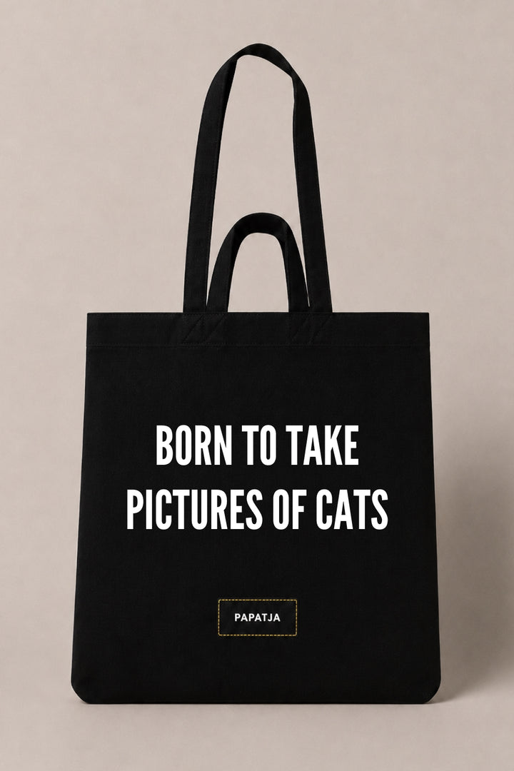 Black cotton PAPATJA tote bag with the quote Born to Take Pictures of Cats, a funny gift for cat lovers who love taking photos of their cat.