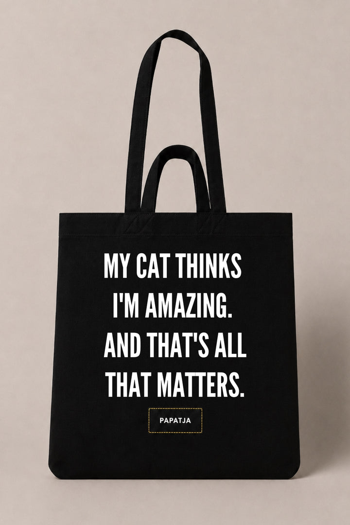 Black cotton PAPATJA tote bag with the quote My Cat Thinks I'm Amazing. And That's All That Matters, a funny gift for cat lovers.