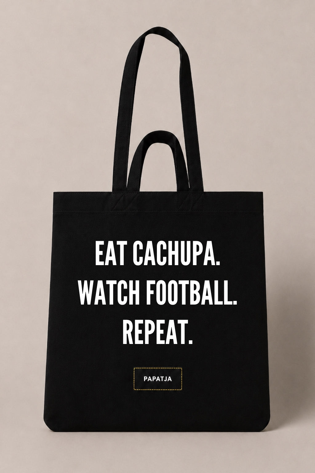 Zwarte katoenen PAPATJA tas met de tekst Eat Cachupa. Watch Football. Repeat., voor Cabo Verde fans die houden van voetbal en cachupa.